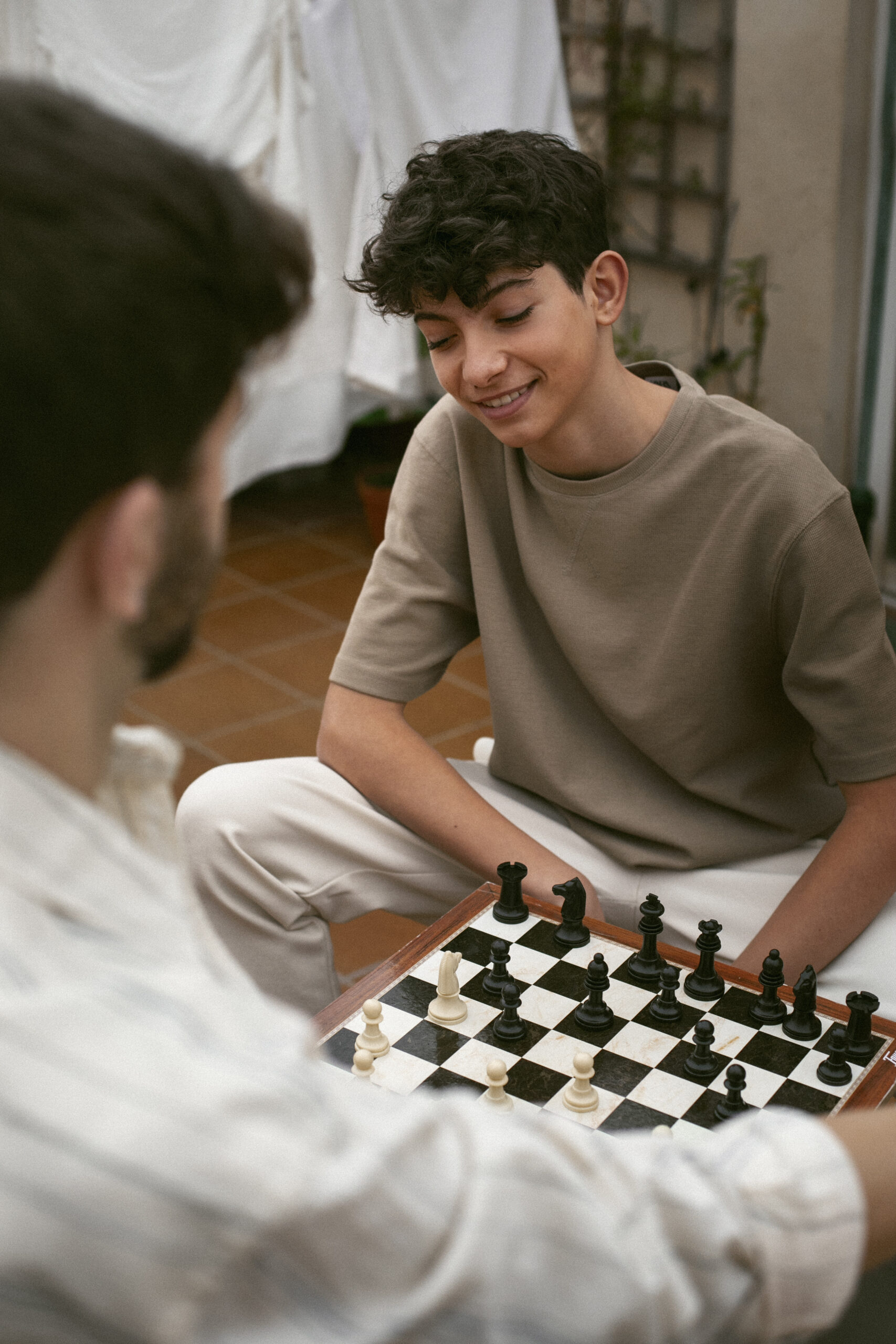 portrait-brothers-playing-chess-together-outdoors